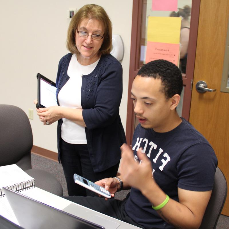 business instructor talking to student at a computer